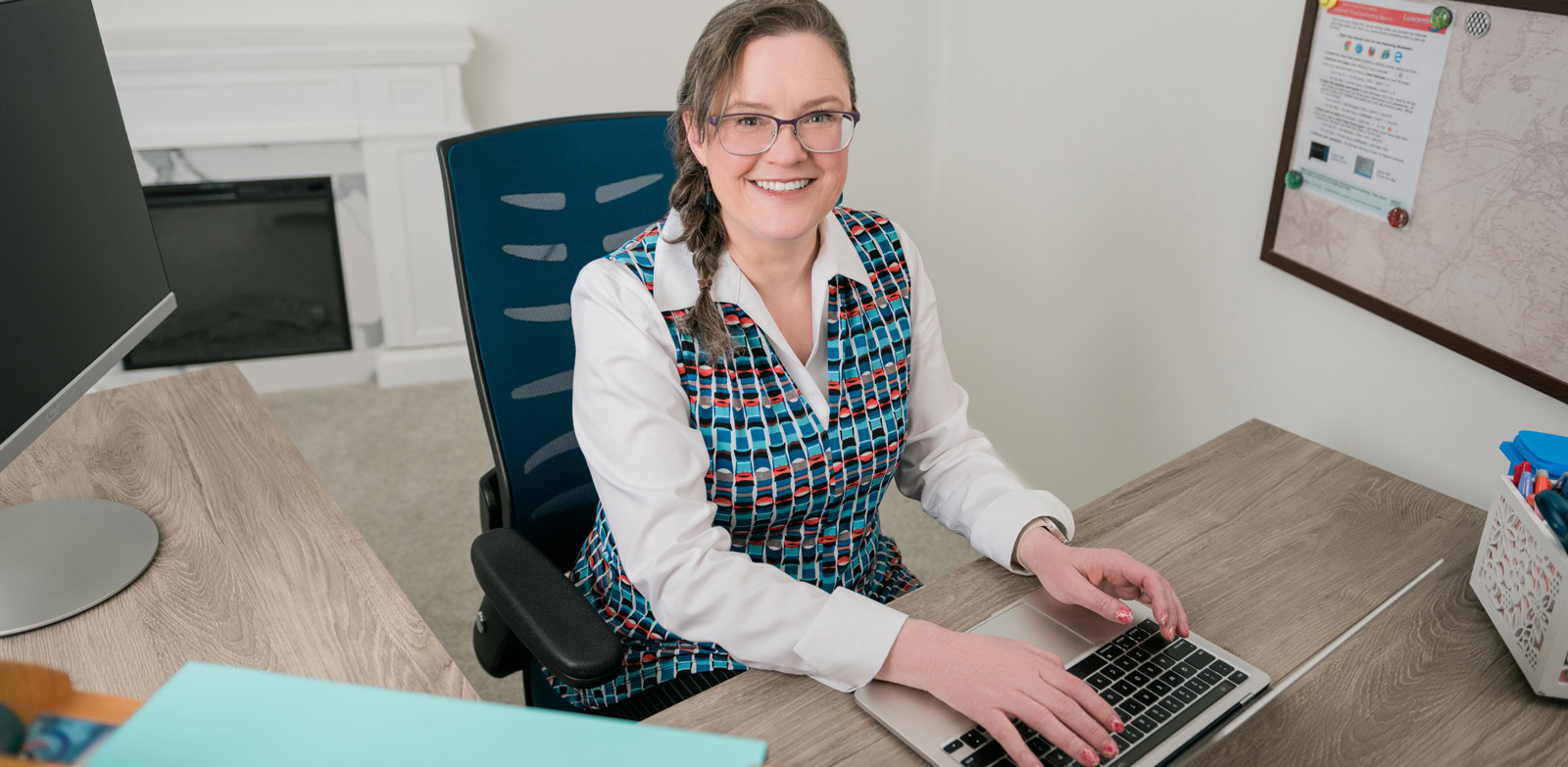 Nicole sitting at her computer in her office