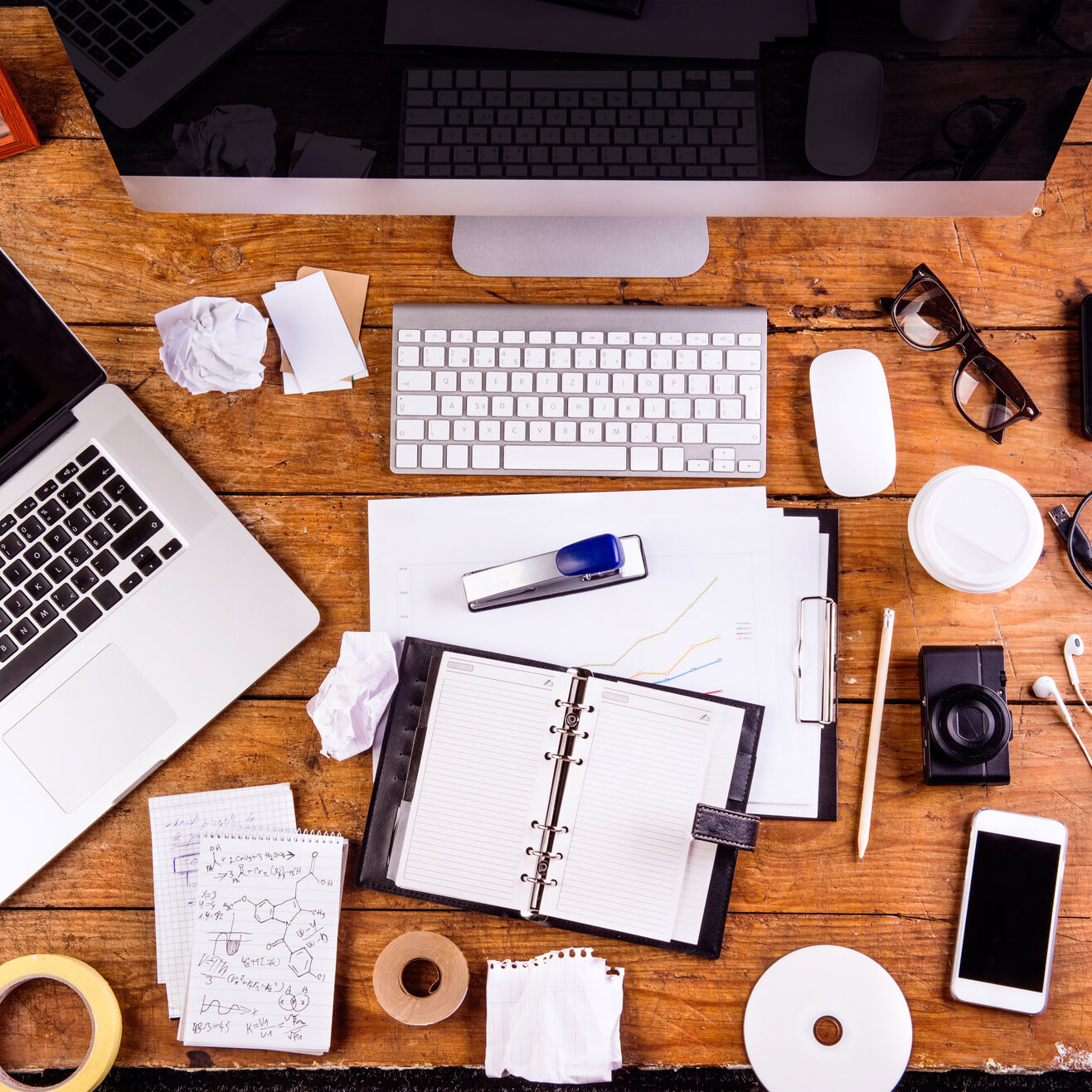 Desk with various gadgets and office supplies. Computer, smart phone, notebook and other devices and stationery around the workplace. Flat lay.